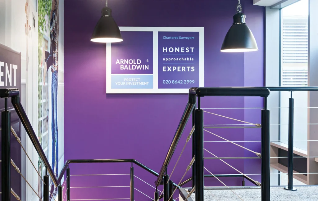 Arnold & baldwin honest approachable experts stairway large office signage on a purple branded wall